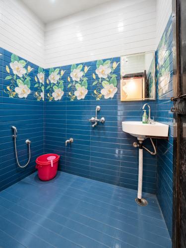 a blue tiled bathroom with a sink and a bucket at Bholenath Guest House 500 Mitter From Shree Ram Manidr in Faizābād