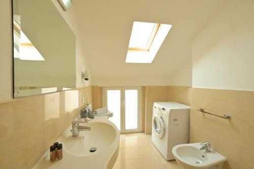 a bathroom with a sink and a toilet and a window at Hotel La Balnearia in Alassio