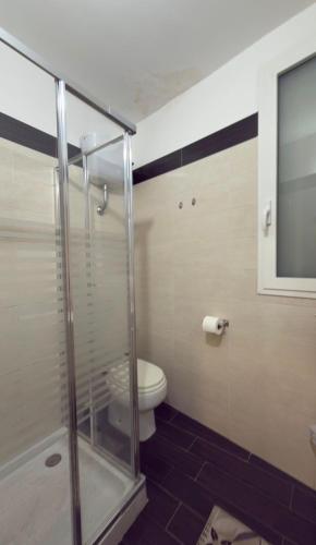 a bathroom with a toilet and a glass shower at AG Scalo d amore house in Naples