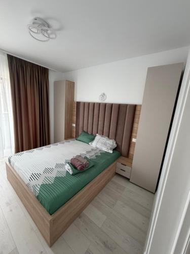 a bedroom with a large bed with green sheets at Apartment in Ploiești 4 in Ploieşti