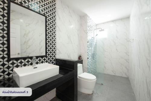 a bathroom with a sink and a toilet and a mirror at Scarlet Poolvilla Pattaya in Na Jomtien