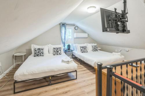 two beds in a room with a balcony at Where Classic Charm Meets Modern Serenity in Pittsburgh