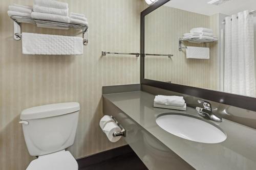 a bathroom with a toilet and a sink and a mirror at Best Western Plus Meridian in Lloydminster