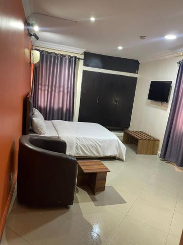 a bedroom with a bed and a couch and a chair at CBC Towers in Lagos