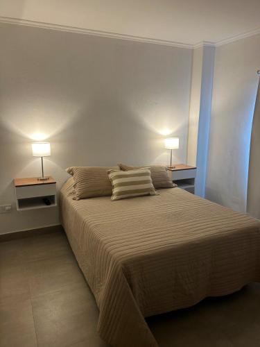 a bedroom with a large bed with two lamps on it at Departamento en Goya Ctes in Goya