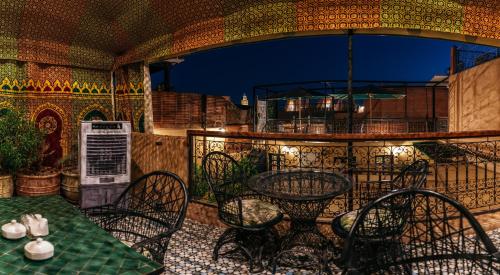 an outdoor patio with tables and chairs on a balcony at The Little Hara in Marrakesh