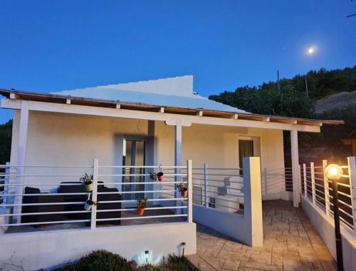 a house with a cow sitting on the front porch at JANAS Country House in Castelsardo