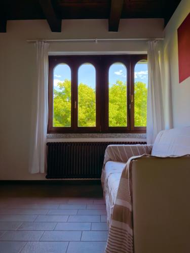 a room with two beds in front of a window at Casa Mario Spacious Garden Apartments, Lake Como in Domaso