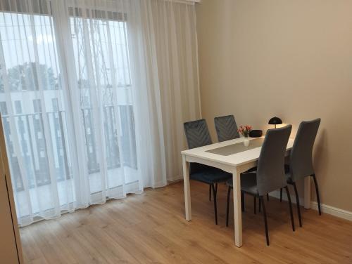 a dining room with a white table and chairs at Royal Apartment in Rumia