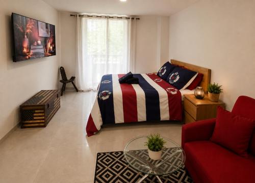 a bedroom with a bed and a couch and a table at Appartement T2 bis à morbier in Morbier