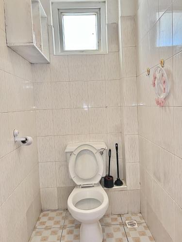 a bathroom with a toilet and a window at tabby stays one bedroom with two beds bamburi in Mombasa