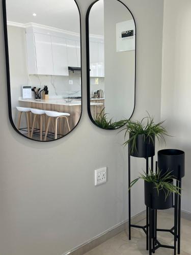 a mirror on a wall in a kitchen with a table at Zahari Villas in Parys