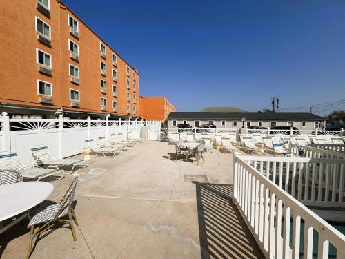 a patio with chairs and tables and a building at Oceanic Hotel in Wildwood