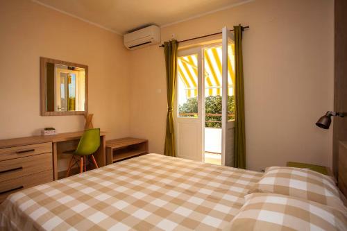 a bedroom with a bed and a desk and a window at Apartment Hotteamo in Silba