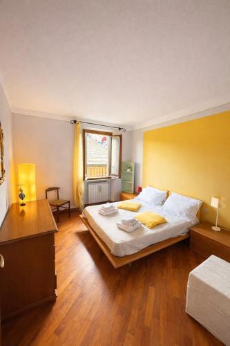 ein Schlafzimmer mit einem großen Bett und einer gelben Wand in der Unterkunft Simona's house in Montaione