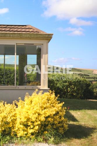 a house with a window and yellow flowers at GC - Villa L'Idéal - Vue Mer in Hervelinghen
