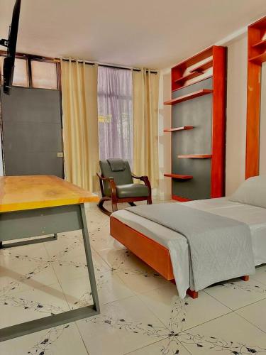 a bedroom with a bed and a desk and a chair at Casa Vacanza Apartamentos in Leticia