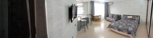 a living room with a bed and a living room with a table at Уютная 1 комнатная квартира на Сейфуллина 21 in Balqash