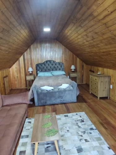 a bedroom with a bed and a couch in a room at Frida's Haus in Nova Petrópolis