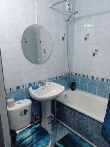a bathroom with a sink and a toilet and a mirror at Уютная 1 комнатная квартира на Сейфуллина 21 in Balqash