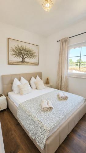 a bedroom with a large bed with two towels on it at Villa Olivia in Banjole