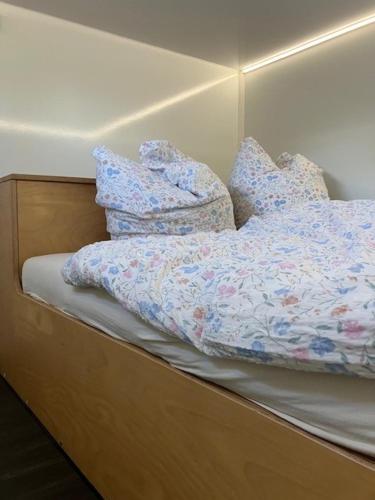 a bed with blue comforter and pillows on it at Reetblick in Haseldorf