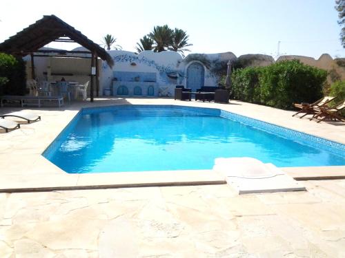 a swimming pool in front of a house at Doukana in Djerba