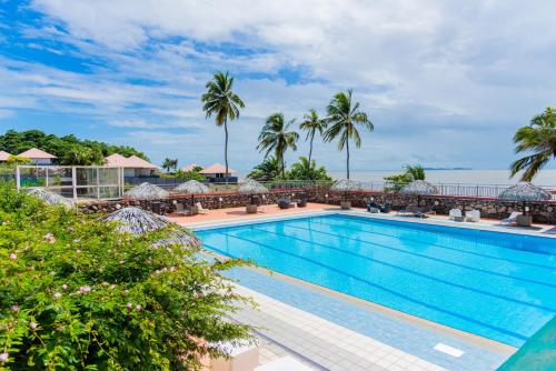 a view of a swimming pool at a resort with palm trees at Hôtel des Roches Kourou in Kourou