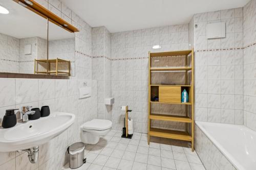 a bathroom with a sink and a toilet and a tub at Casa Materi Geldersheim in Geldersheim