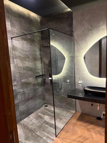 a bathroom with a glass shower and a sink at SA Farms in Lahore