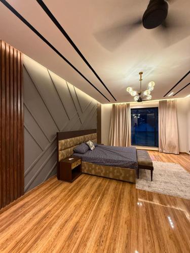 a bedroom with a bed and wooden floors and a ceiling at SA Farms in Lahore