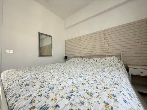 a bedroom with a bed with a floral comforter at M473 - Marcelli, trilocale con posto auto e wifi in Marcelli