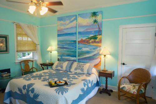 una camera da letto con un letto e un dipinto sul muro di Iao Valley Inn a Wailuku