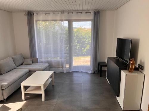 a living room with a couch and a tv at Ferienwohnung Talglück in Weissach Im Tal