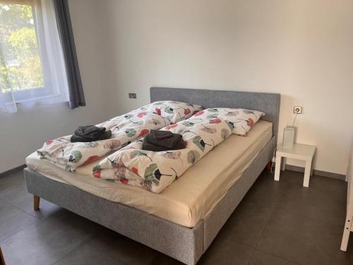 a bed with a blanket on it with a window at Ferienwohnung Talglück in Weissach Im Tal