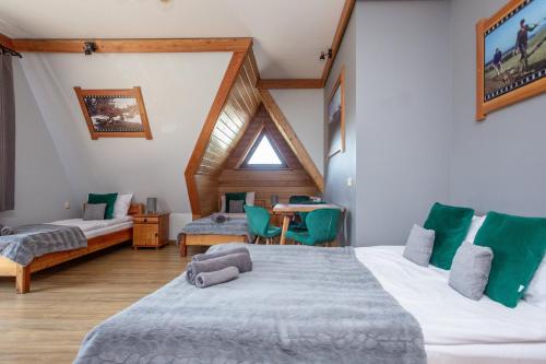 a hotel room with two beds and a table at U Studniara in Murzasichle