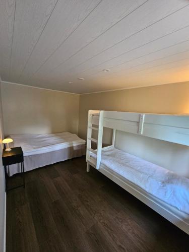 two bunk beds in a room with a wooden floor at Sandmo Holiday Home 13 in Eckerö