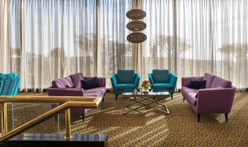 a waiting room with purple and blue chairs and a table at Seven Arches Hotel in Jerusalem