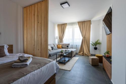 a bedroom with a bed and a living room at Apartman Kika Knjaževac in Knjazevac.