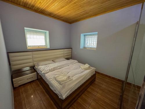a small bedroom with a bed and two windows at Gald Garden in Dilijan