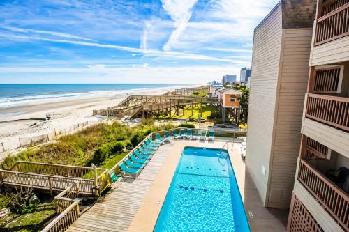 a view of the pool and beach from the balcony of a building at Ocean Forest Colony in Myrtle Beach