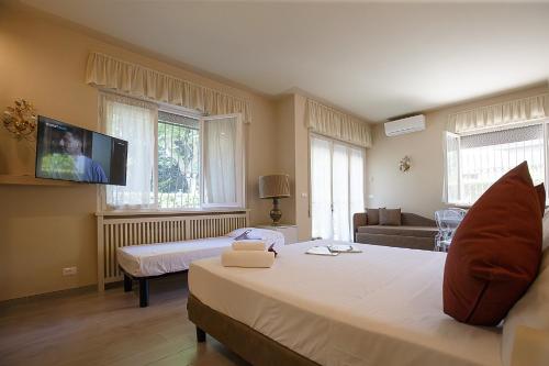 a bedroom with a large bed and a tv on the wall at B&B Ortensia in Forte dei Marmi