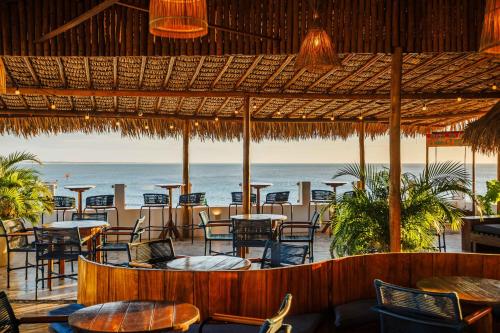 a restaurant on the beach with tables and chairs at Vila Gallina Pousada in Jericoacoara