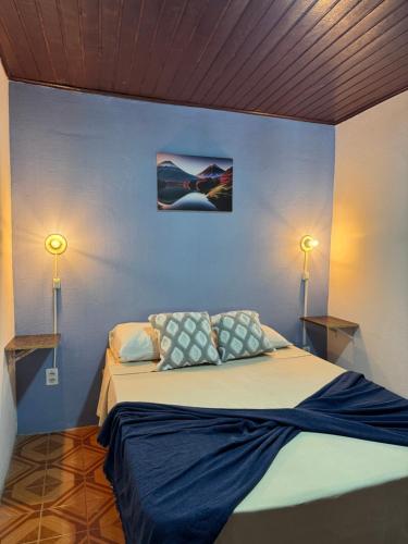 a bedroom with a large bed with two lamps at Hostel amazonia in Búzios