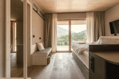 a bedroom with a bed and a large window at Hotel Tulie in Most na Soči