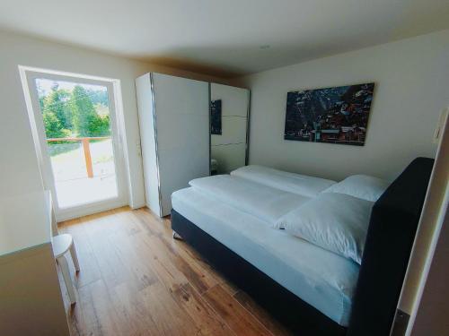 a bedroom with a large bed and a large window at Apartment Pegasus by Salzkammergood Living in Tauplitz