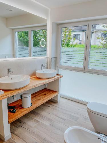 a bathroom with two sinks and two windows at Apartment Pegasus by Salzkammergood Living in Tauplitz