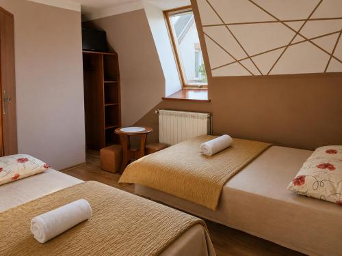 a bedroom with two beds and a window at Pokoje Szmaragd in Kudowa-Zdrój