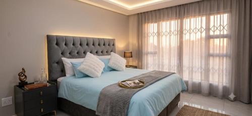 a bedroom with a large bed with a large window at The Kempton Star in Kempton Park