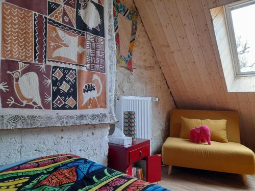 a bedroom with a bed and a chair in a room at Au Coeur de la Cour in Saint-Georges-sur-Cher